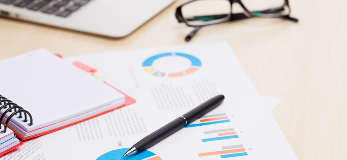 Office desk workplace with laptop and reports