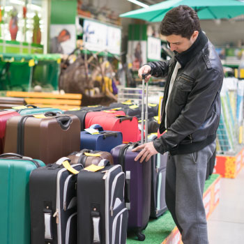 male-customer-choosing-travel-suitcase-8ELBUA5